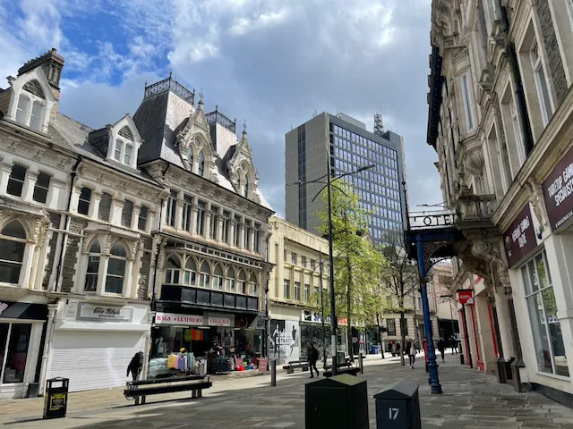 A Newport city centre street with historic shopfronts and modern buildings.